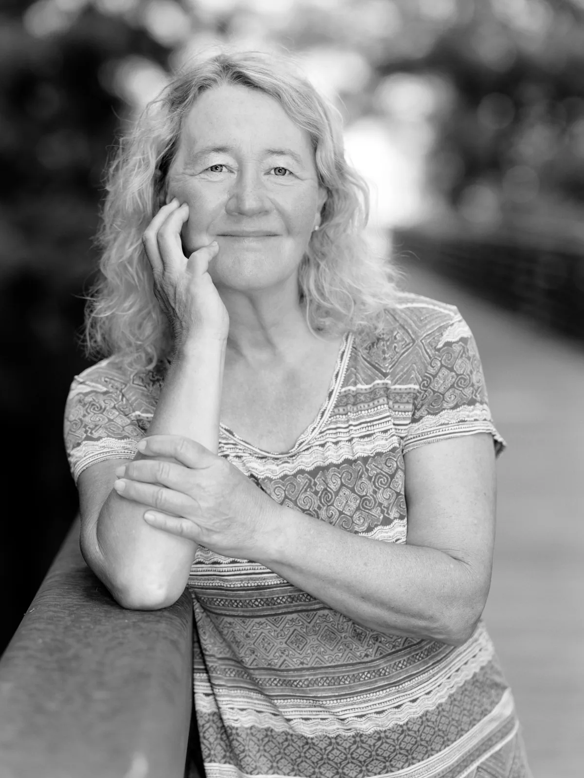 Carol Greider seated outdoors in a black-and-white portrait.